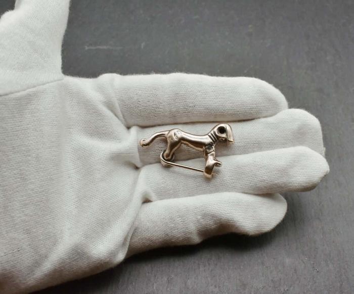 Kleine keltische Pferdchenfibel aus Bronze auf Hand